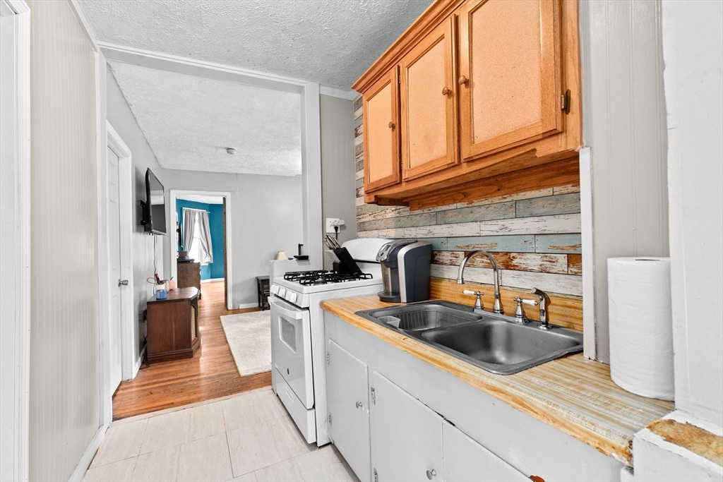 93 Warren Street Fall River, MA 02721 - Photo 21 of 42 a kitchen with stainless steel appliances granite countertop a sink stove and cabinets