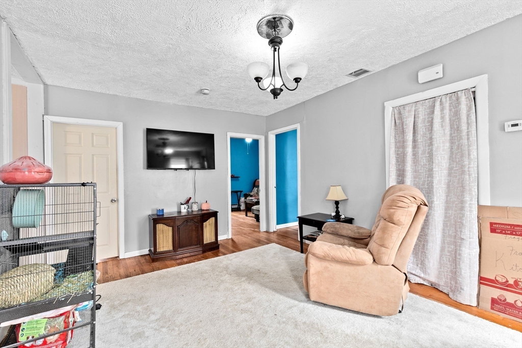 93 Warren Street Fall River, MA 02721 - Photo 23 of 42 a living room with furniture a flat screen tv and a chandelier