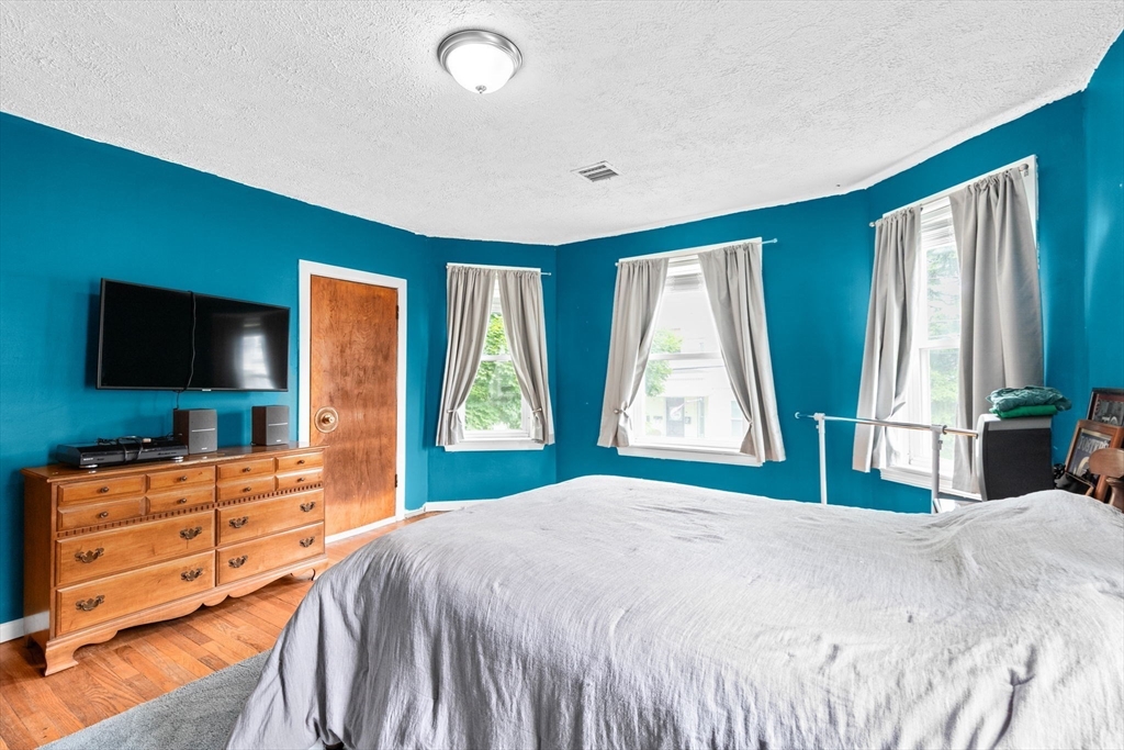 93 Warren Street Fall River, MA 02721 - Photo 25 of 42 a bedroom with a bed and a flat tv screen on dresser