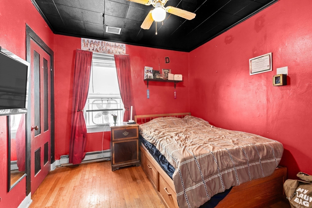 93 Warren Street Fall River, MA 02721 - Photo 27 of 42 a bedroom with a bed and wooden floor