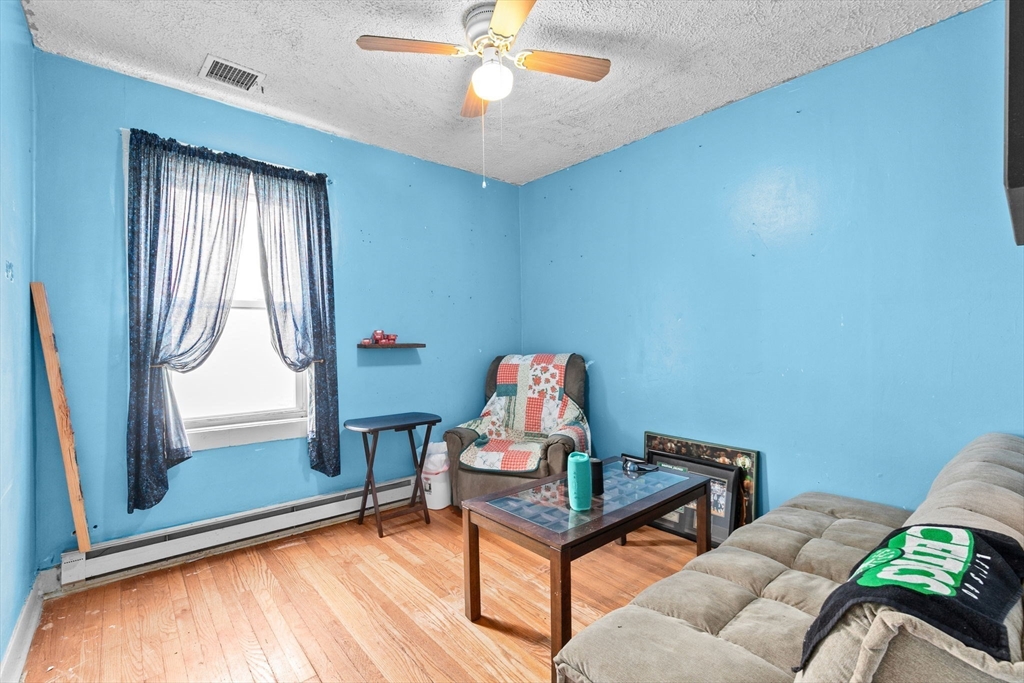 93 Warren Street Fall River, MA 02721 - Photo 28 of 42 a living room with furniture a window and a chandelier