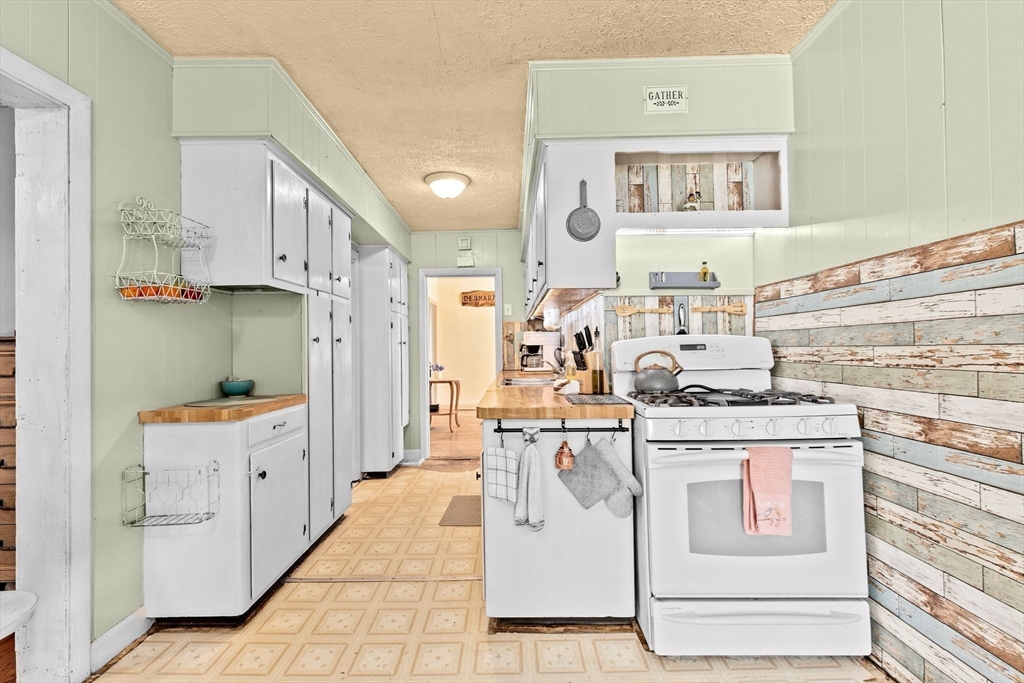 93 Warren Street Fall River, MA 02721 - Photo 4 of 42 a kitchen with white cabinets and stove