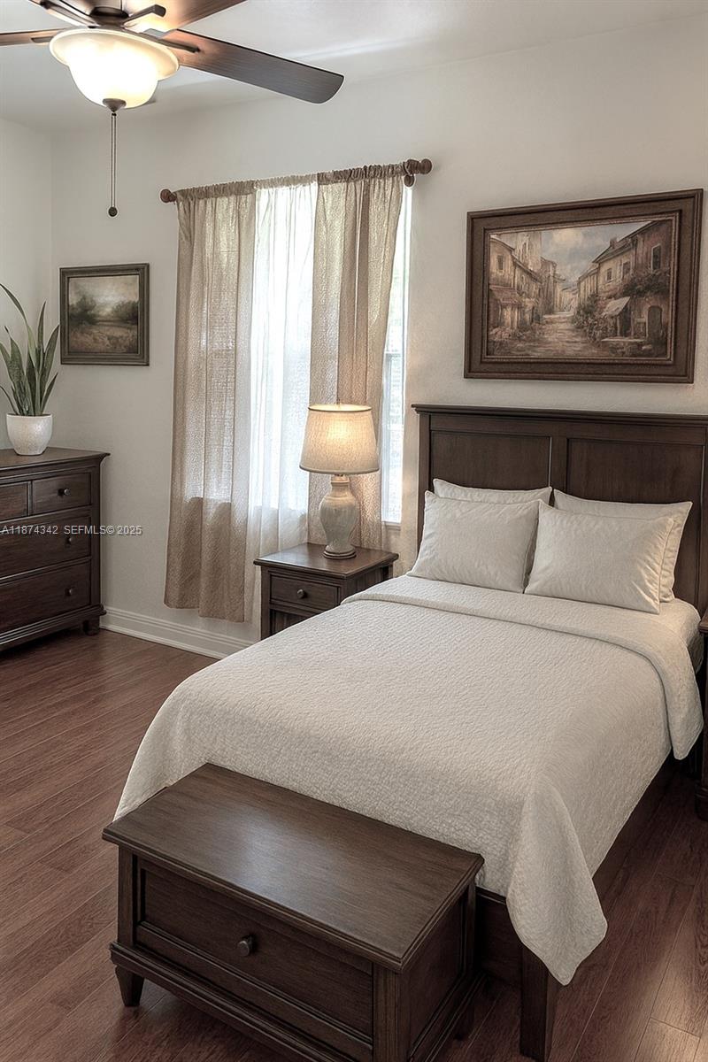 6312 West Sample Road, Unit 6312 Coral Springs, FL 33067 - Photo 11 of 21 a bedroom with a bed and wooden floor