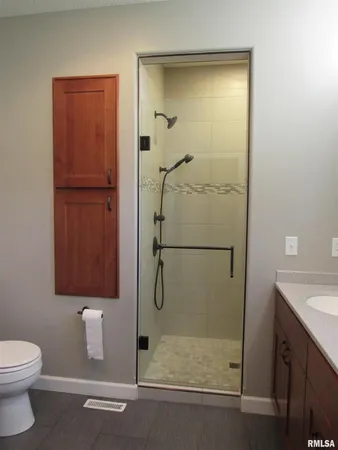a bathroom with a shower a toilet and sink