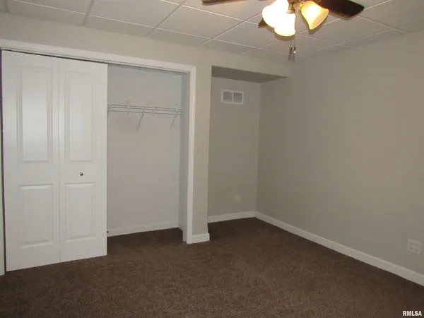 an empty room with a chandelier fan