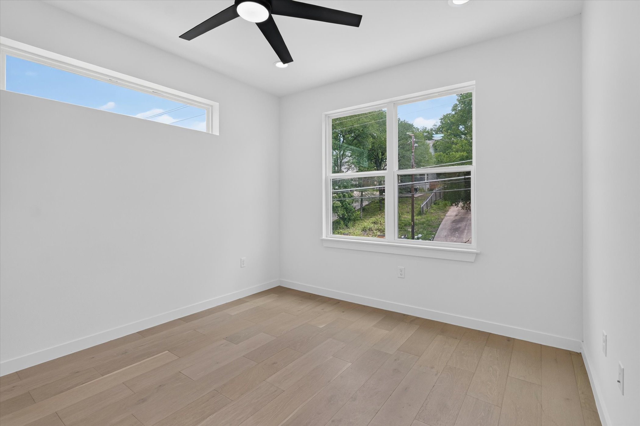 5305 Ledesma Road, Unit 1 Austin, TX 78721 - Photo 16 of 29 A well-lit bedroom features hardwood flooring and generous natural light from multiple windows.