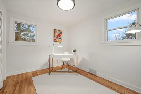 a view of a workspace with furniture and a window