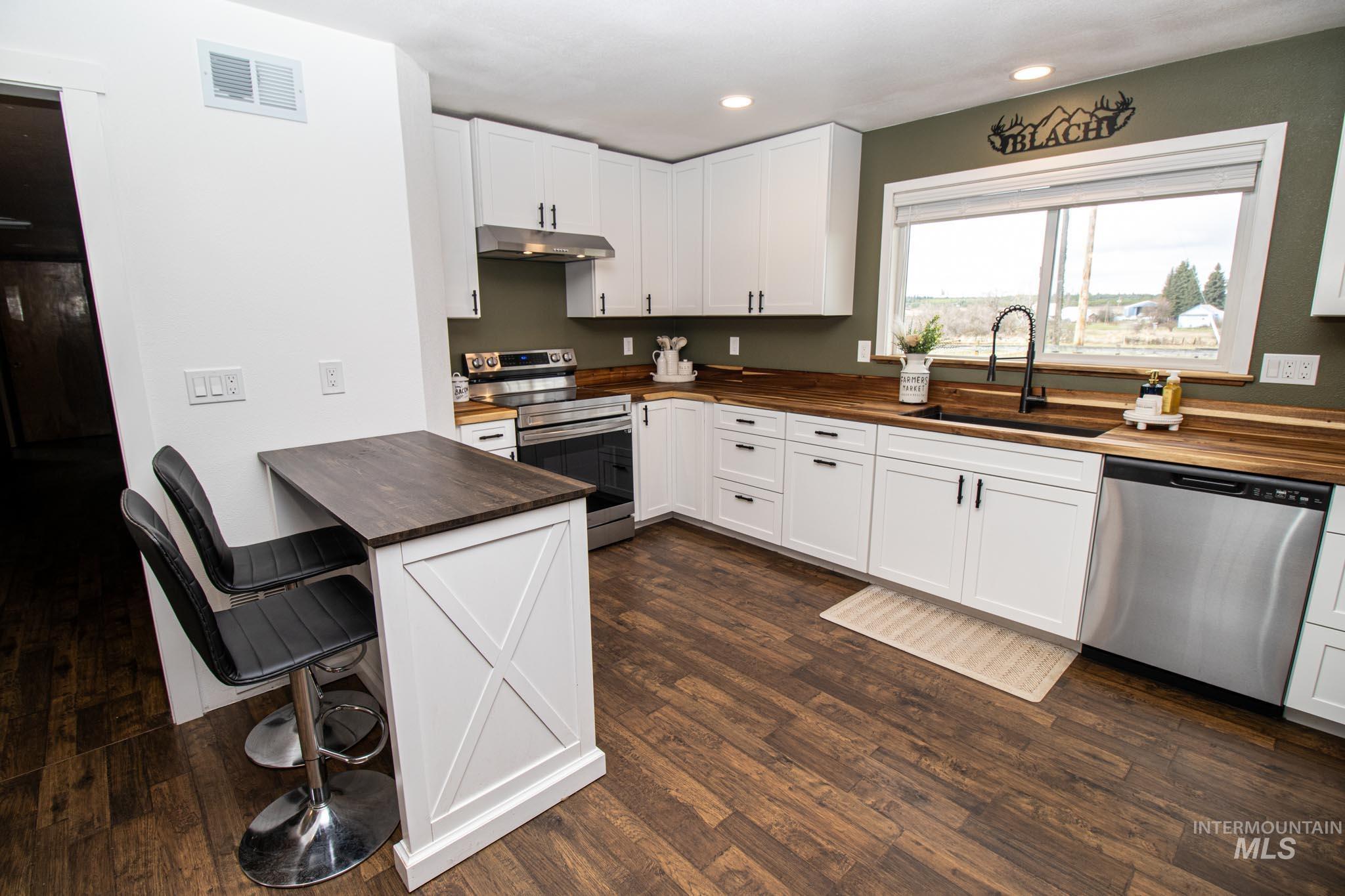 272 Cemetery Road Weippe, ID 83553 - Photo 17 of 43 Kitchen featuring wood counters, stainless steel appliances, a kitchen breakfast bar, dark wood finished floors, and recessed lighting