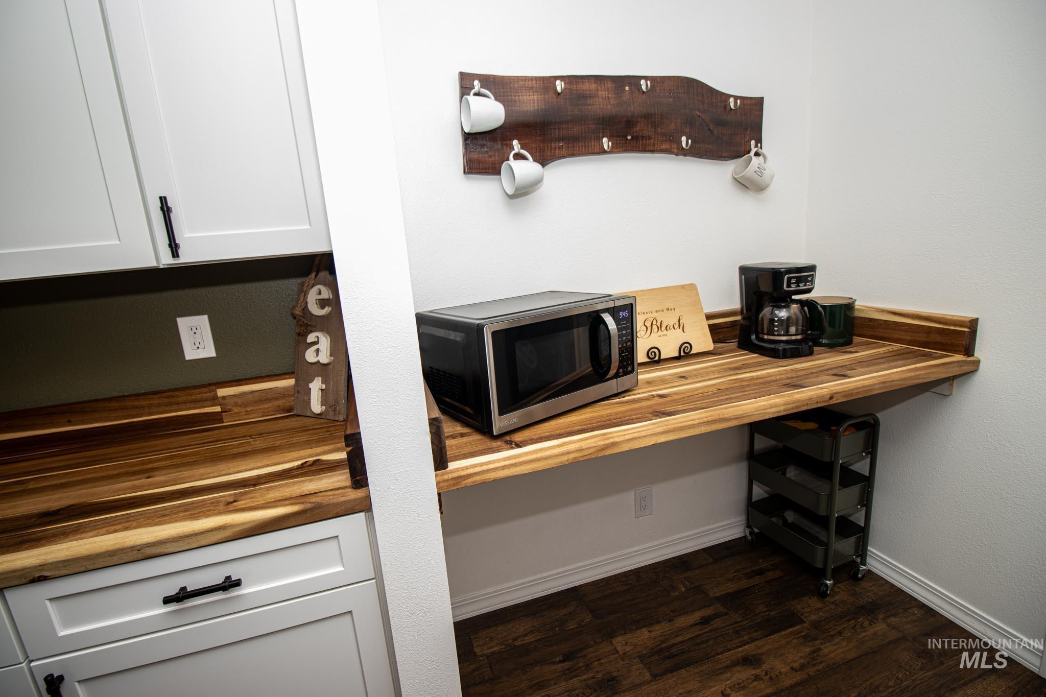 272 Cemetery Road Weippe, ID 83553 - Photo 19 of 43 Detailed view of wooden counters, stainless steel microwave, white cabinetry, dark wood-type flooring, and built in study area