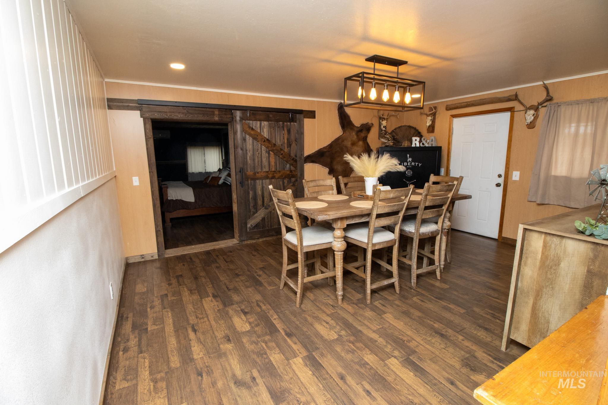 272 Cemetery Road Weippe, ID 83553 - Photo 23 of 43 Dining room featuring a barn door and dark wood-style floors