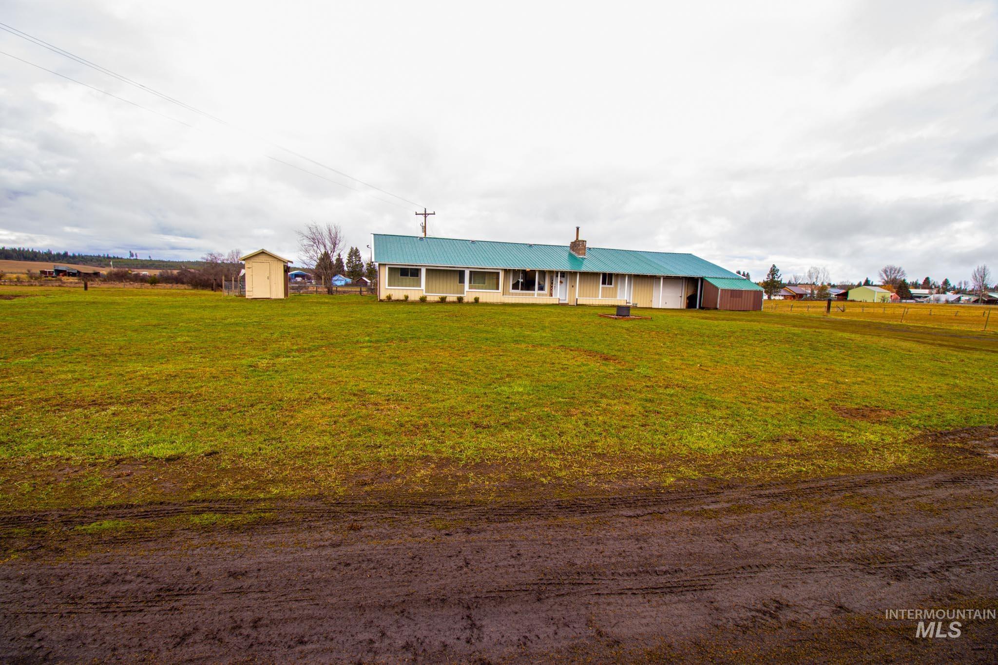 272 Cemetery Road Weippe, ID 83553 - Photo 32 of 43 View of front of property featuring a metal roof, a storage shed, a front yard, and a chimney