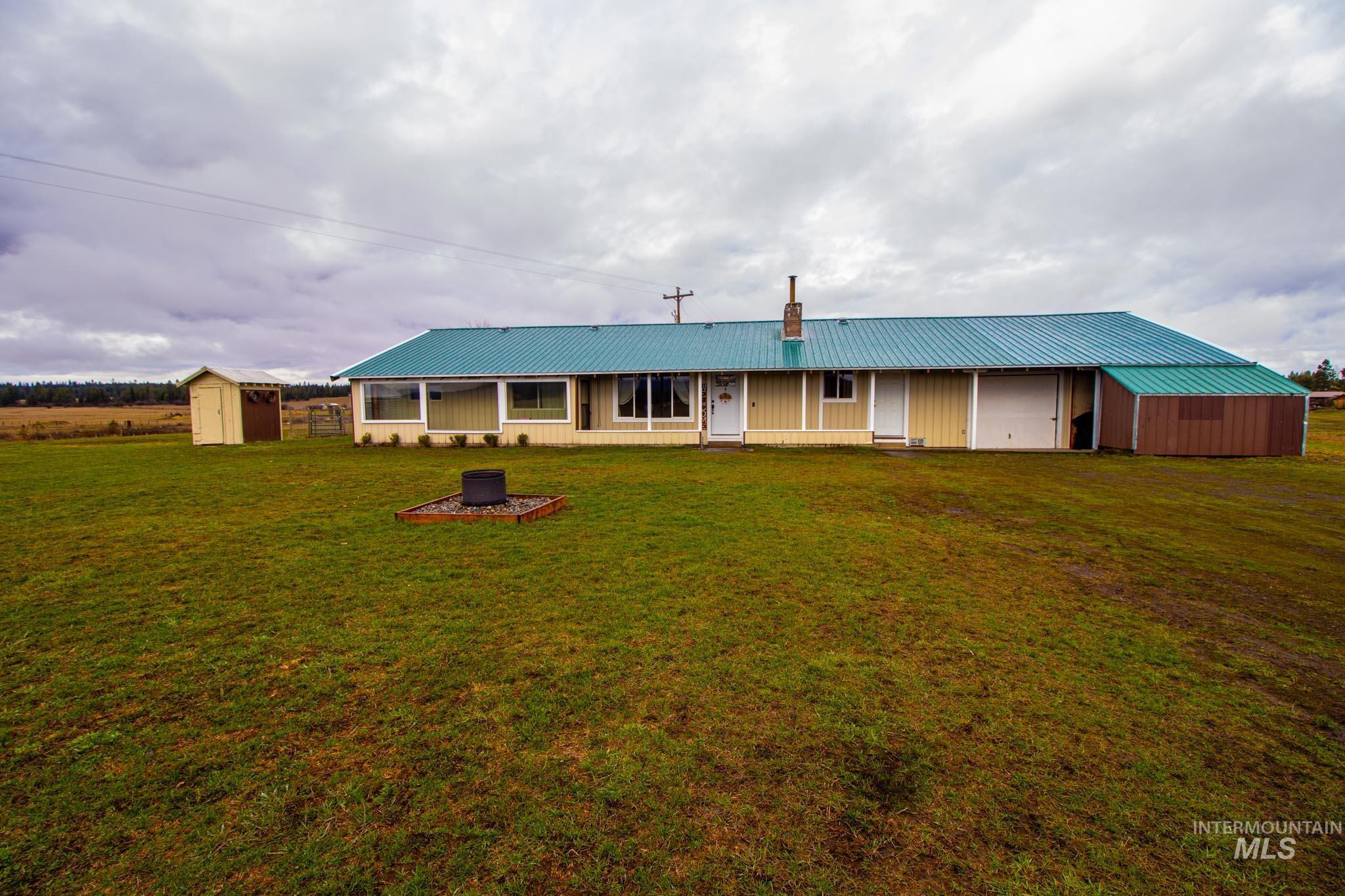 272 Cemetery Road Weippe, ID 83553 - Photo 33 of 43 View of front of property with a storage unit, a metal roof, a front yard, and a chimney