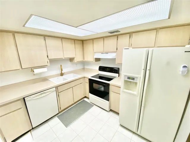 a kitchen with white cabinets and white appliances