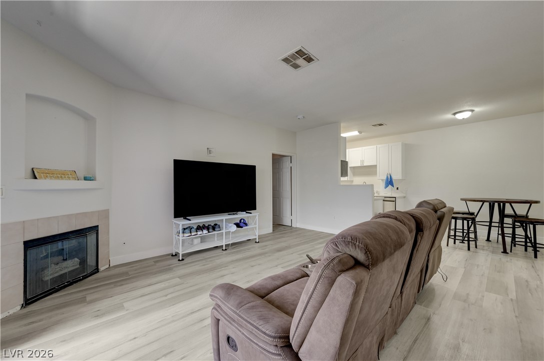 4730 East Craig Road, Unit 1155 Las Vegas, NV 89115 - Photo 8 of 41 Wood-look flooring and a built-in fireplace create a warm, inviting living space.