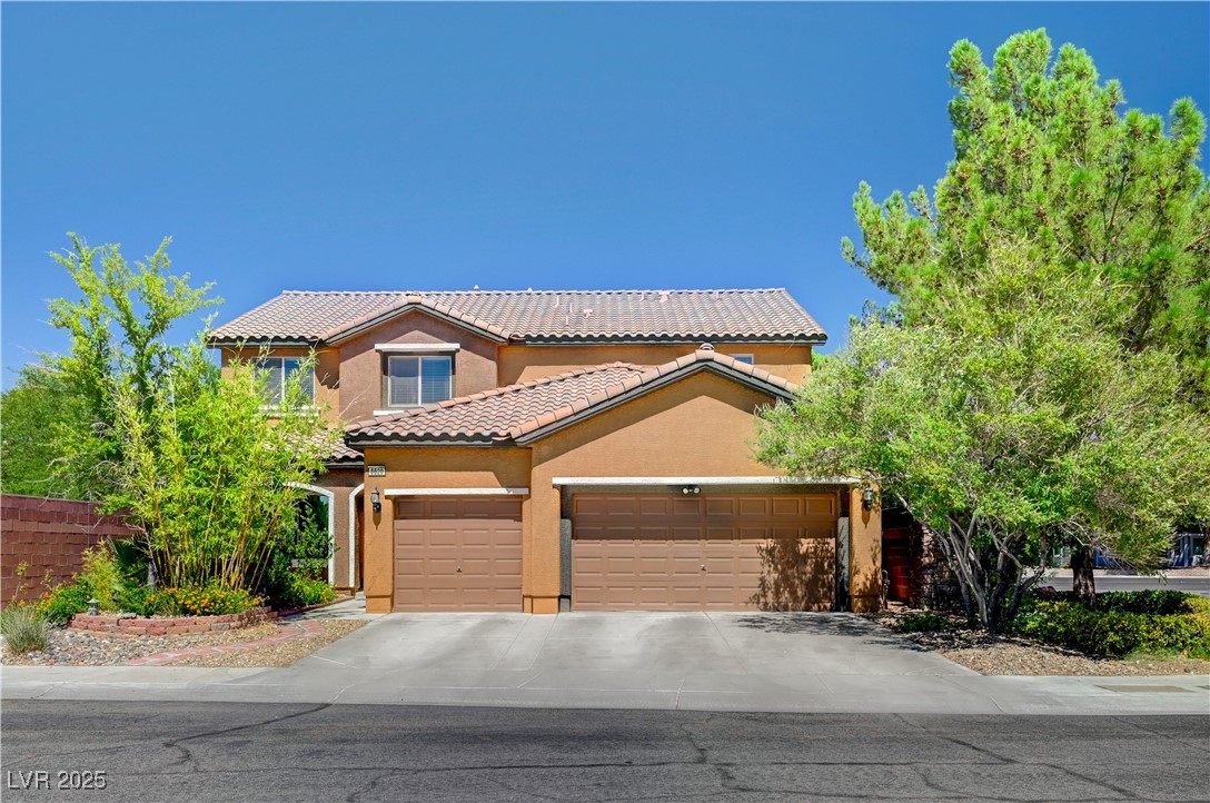 Mediterranean / spanish home with stucco siding, concrete driveway, a tiled roof, and a garage