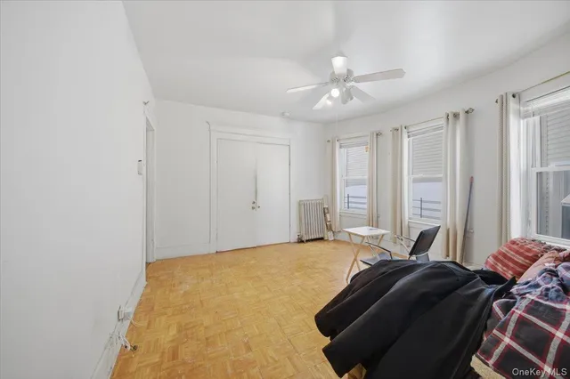 an empty room with windows and fan