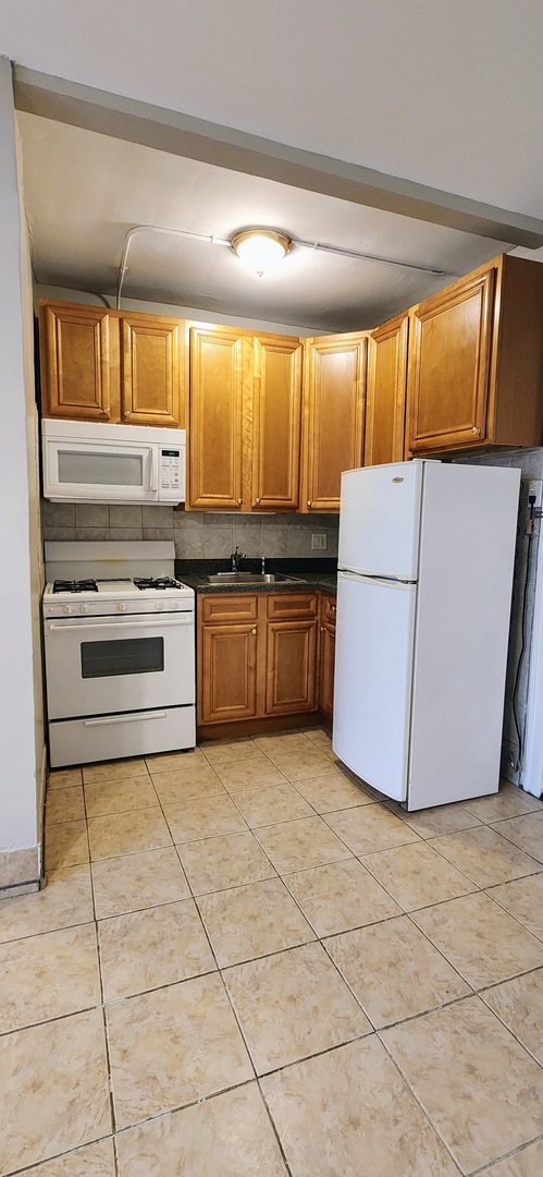 4764 North Virginia Avenue, Unit 214 Chicago, IL 60625 - Photo 7 of 12 a kitchen with stainless steel appliances granite countertop a stove a sink and a microwave
