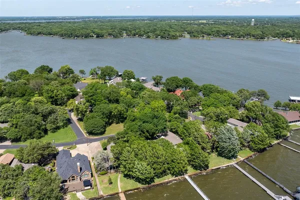an aerial view of a house with a yard and lake view