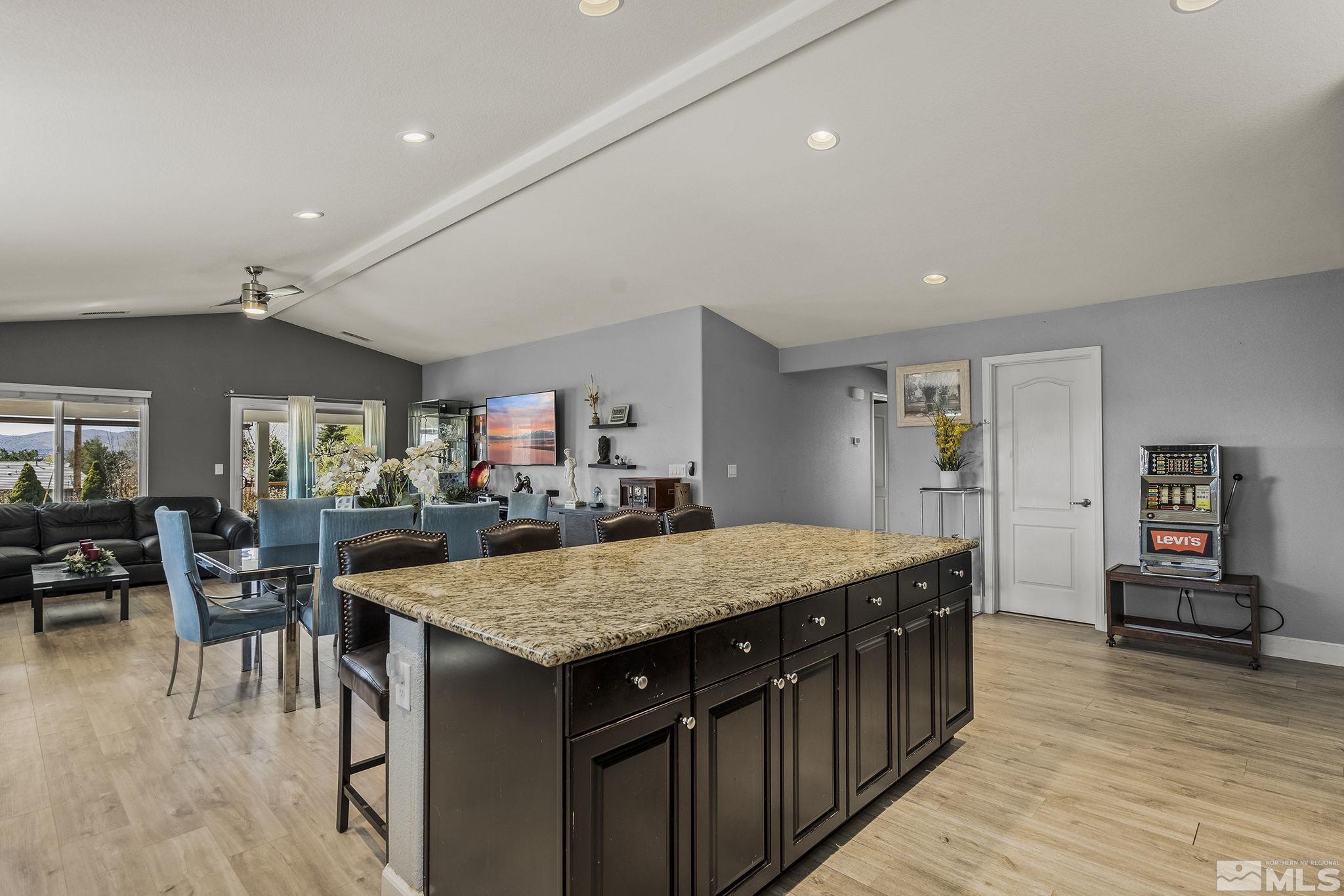 7707 Rhythm Circle Sparks, NV 89436 - Photo 11 of 25 a kitchen with granite countertop center island wooden floor and stainless steel appliances