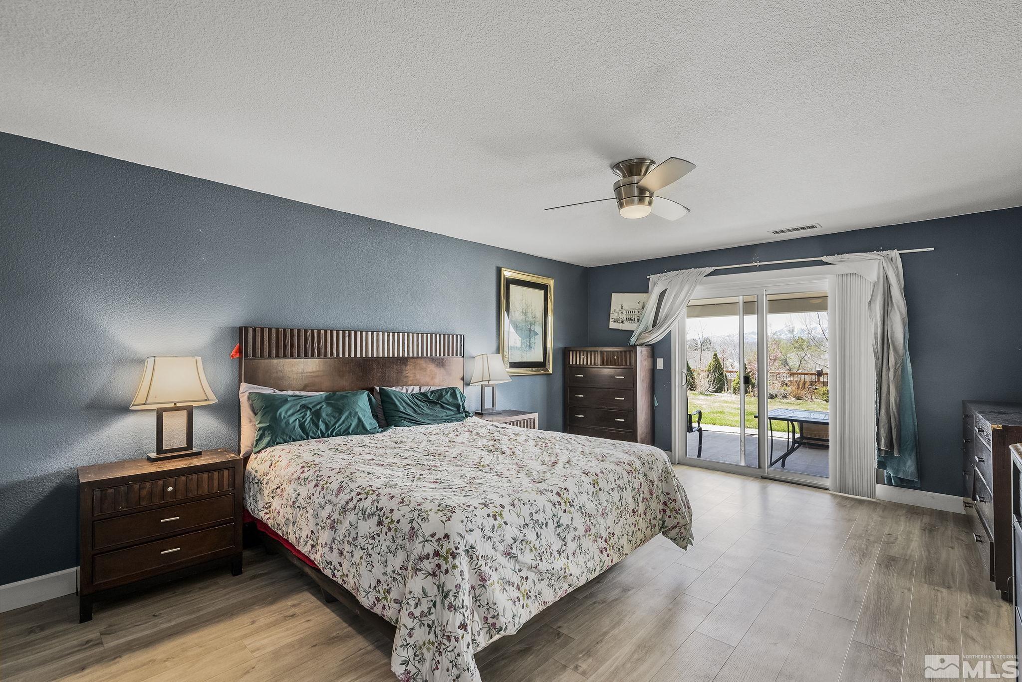 7707 Rhythm Circle Sparks, NV 89436 - Photo 12 of 25 a bedroom with a large bed and a tv on table