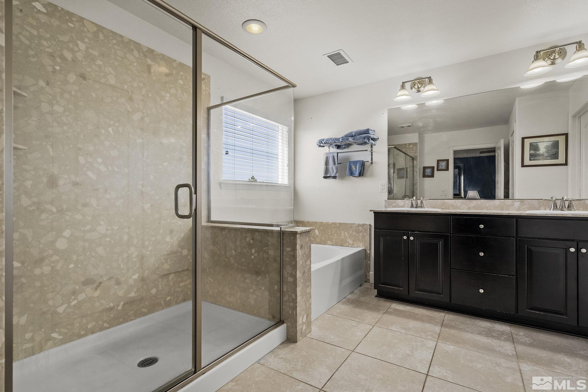 7707 Rhythm Circle Sparks, NV 89436 - Photo 13 of 25 a spacious bathroom with a granite countertop sink mirror and shower