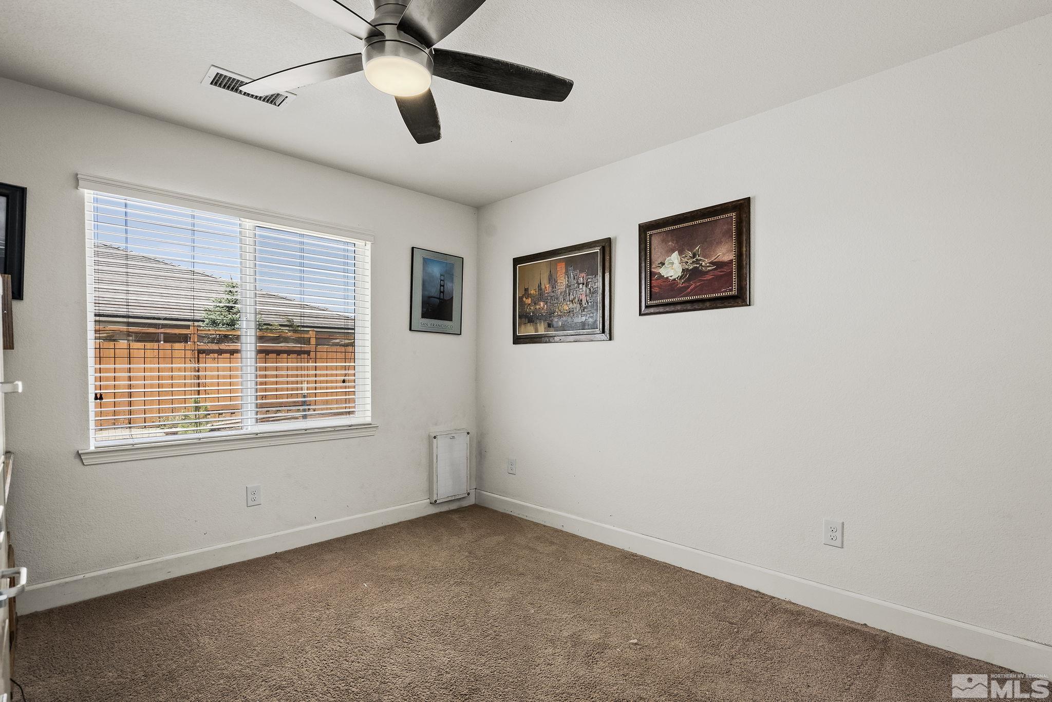 7707 Rhythm Circle Sparks, NV 89436 - Photo 15 of 25 a view of an empty room with a window and a ceiling fan