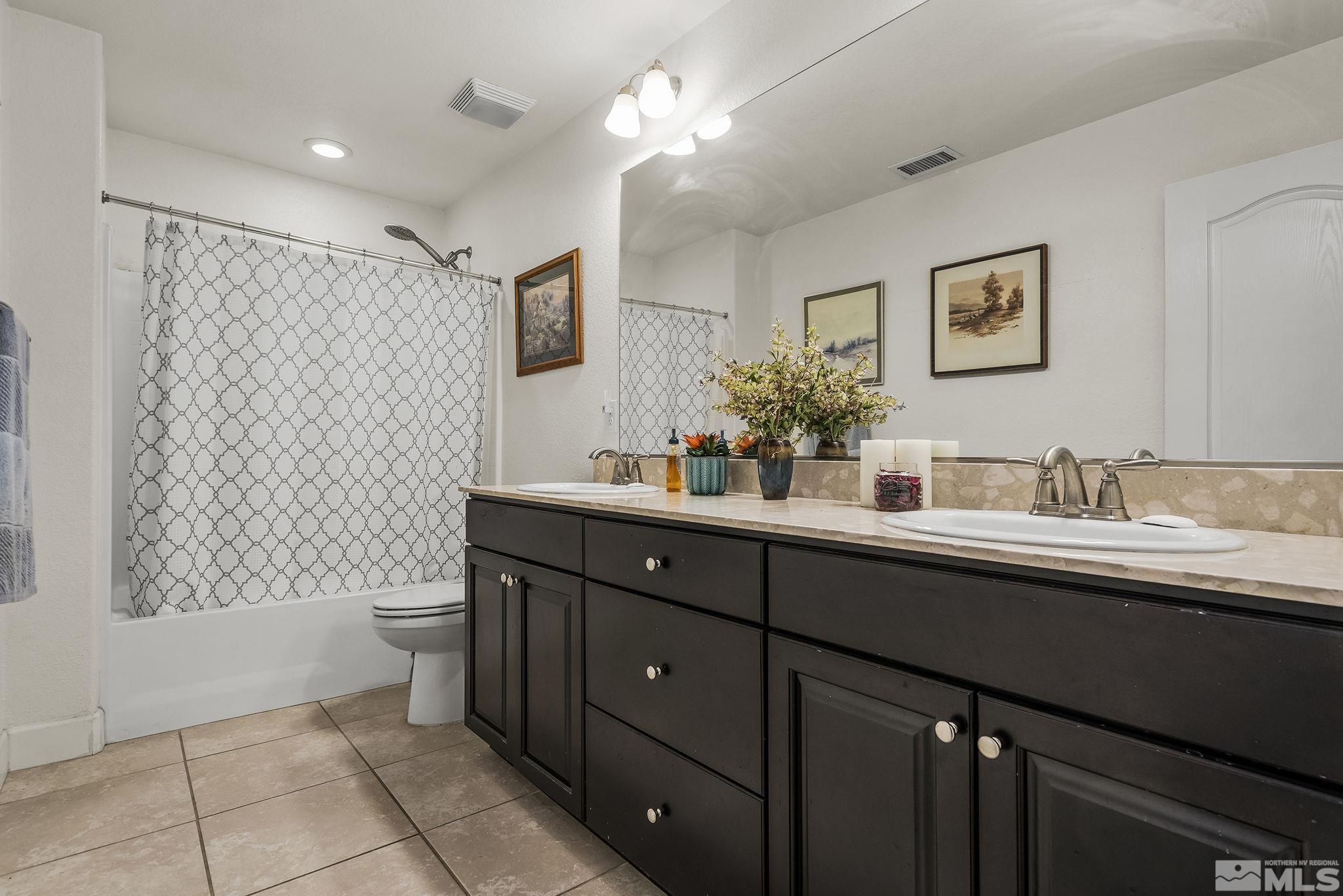 7707 Rhythm Circle Sparks, NV 89436 - Photo 17 of 25 a bathroom with a double vanity sink mirror and toilet