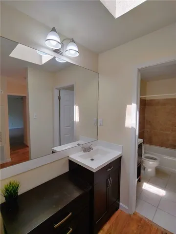 a bathroom with a sink a large mirror and a light fixture