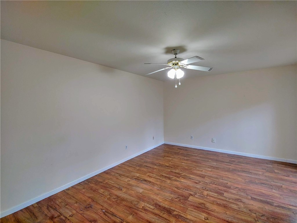 8340 Fathom Circle, Unit 401D Austin, TX 78750 - Photo 15 of 16 a view of a room with wooden floor and a chandelier fan