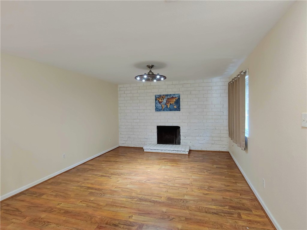 8340 Fathom Circle, Unit 401D Austin, TX 78750 - Photo 4 of 16 a view of an empty room with wooden floor and a fireplace