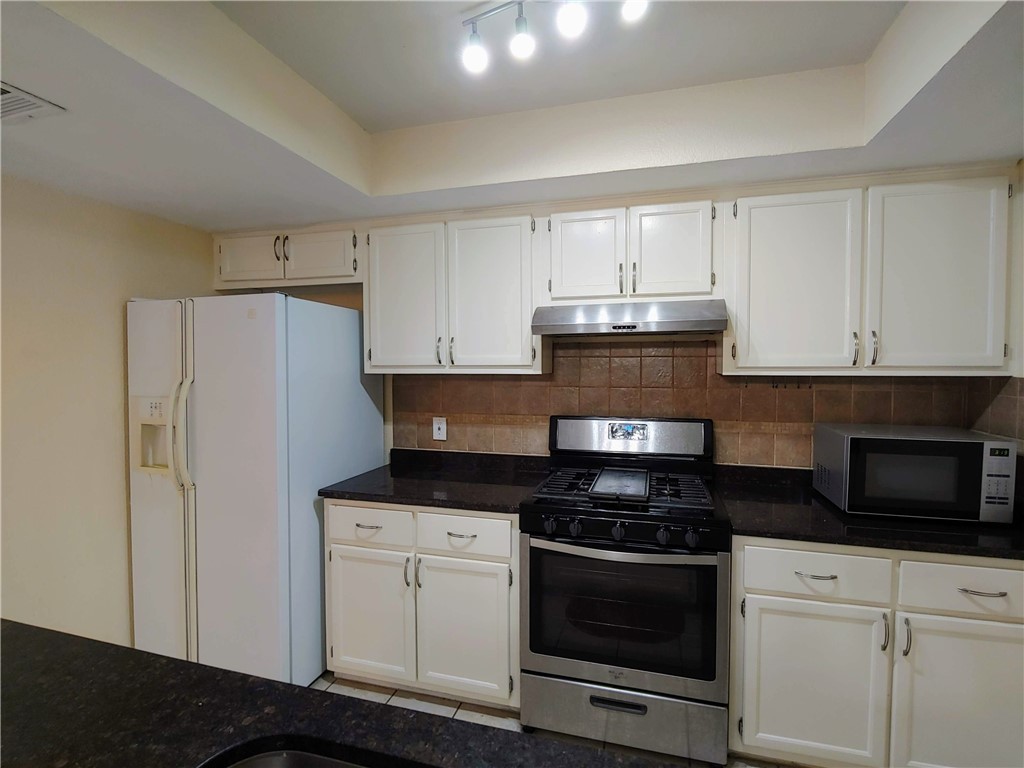8340 Fathom Circle, Unit 401D Austin, TX 78750 - Photo 5 of 16 a kitchen with stainless steel appliances granite countertop a stove a refrigerator and a microwave
