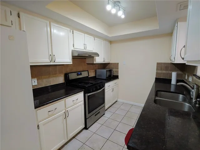 a kitchen with granite countertop a stove and a sink