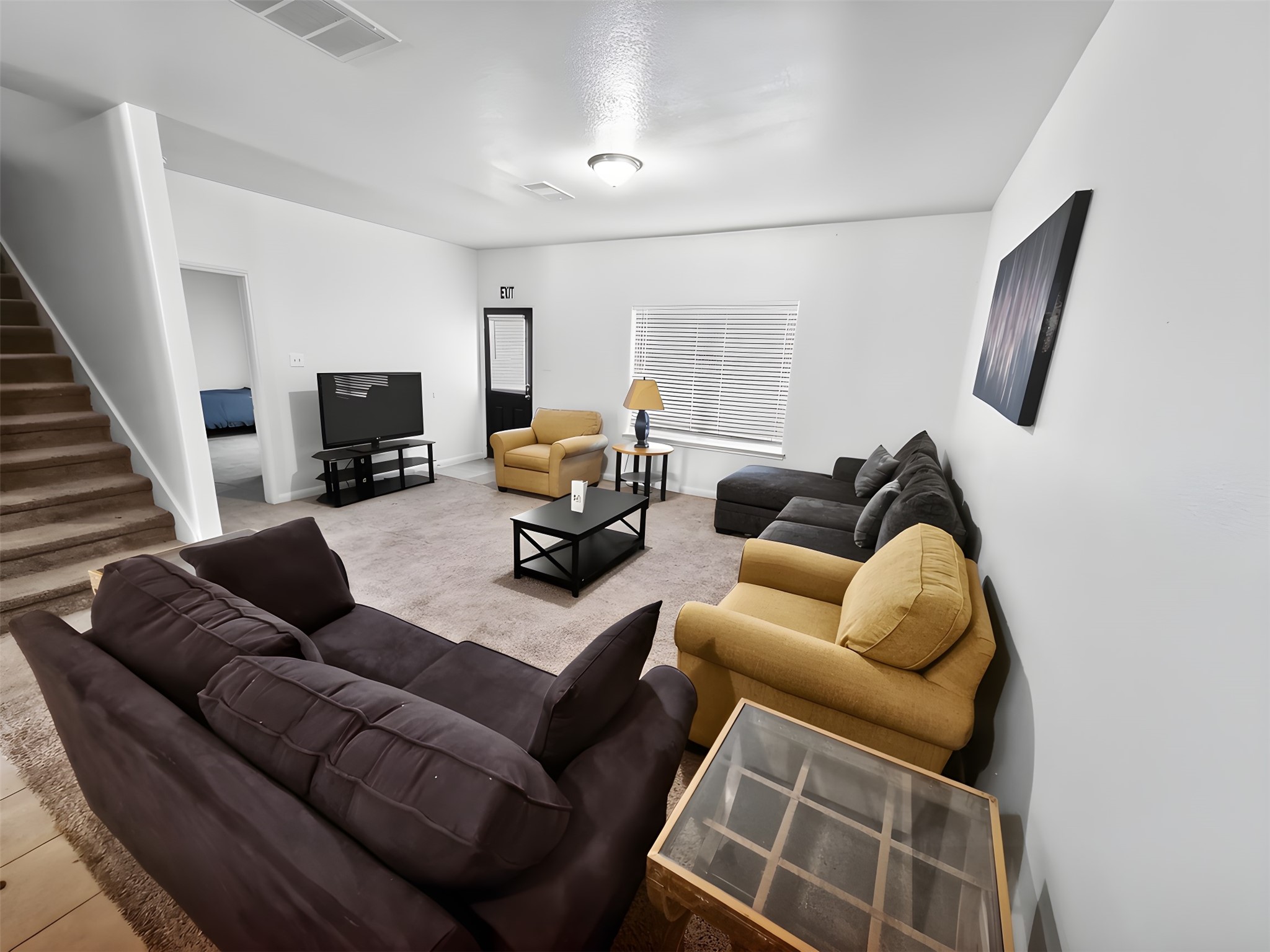 5127 Oak Briar Lane Rosenberg, TX 77469 - Photo 10 of 21 Another look at the large living room showing stairs to upstairs, back patio door, and doorway to primary bedroom.