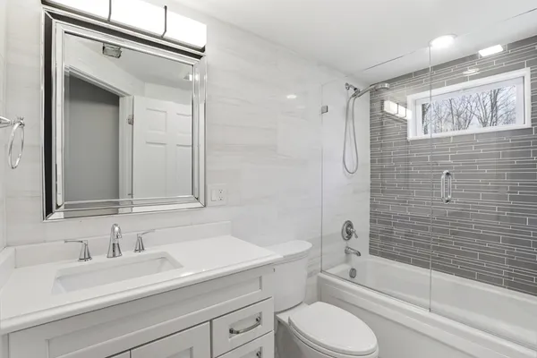 a bathroom with a sink a toilet and shower