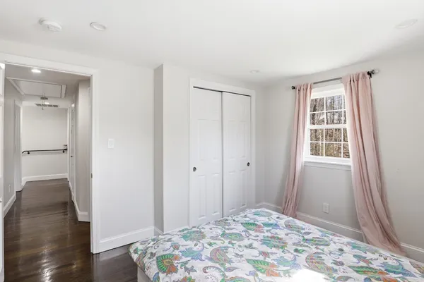 a view of a bedroom with wooden floor and bathroom