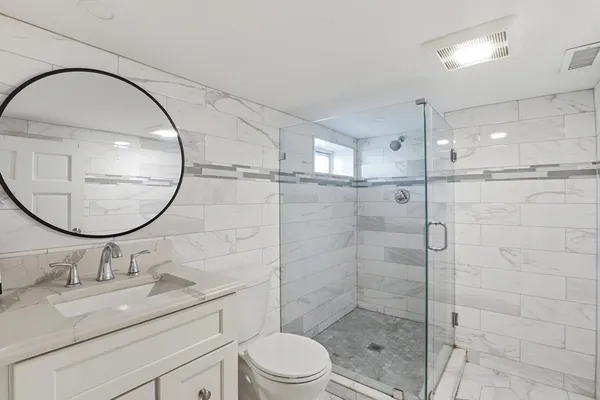 a bathroom with a sink a toilet and a mirror