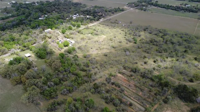 a view of a dry yard with green space