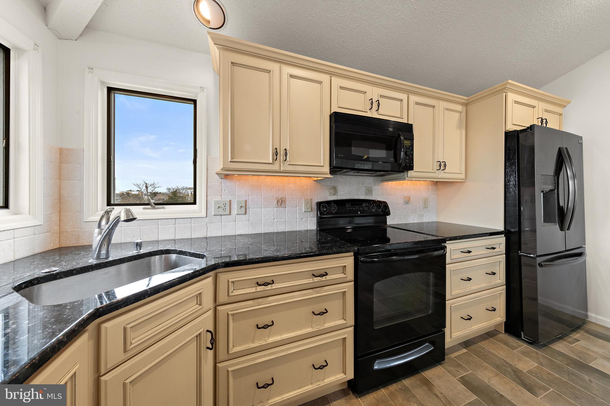 20 East 8th Street Barnegat Light, NJ 08006 - Photo 21 of 80 a kitchen with granite countertop a sink stove and refrigerator