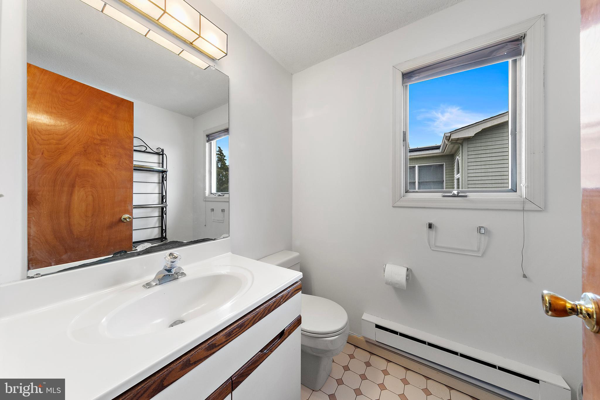 20 East 8th Street Barnegat Light, NJ 08006 - Photo 22 of 80 a bathroom with a sink a toilet and mirror