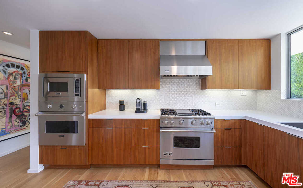 1566 Rising Glen Road Los Angeles, CA 90069 - Photo 12 of 32 a kitchen with stainless steel appliances granite countertop a stove a sink and a refrigerator