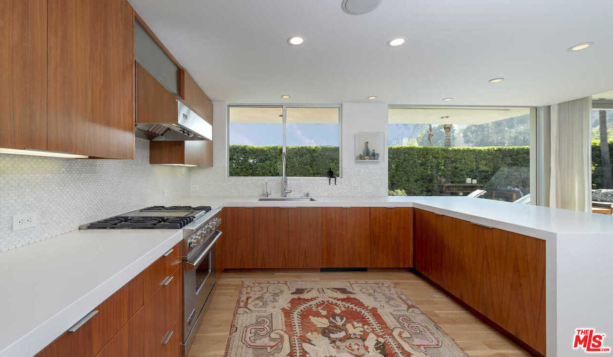 1566 Rising Glen Road Los Angeles, CA 90069 - Photo 13 of 32 a kitchen with stainless steel appliances granite countertop a sink a stove and a wooden cabinets