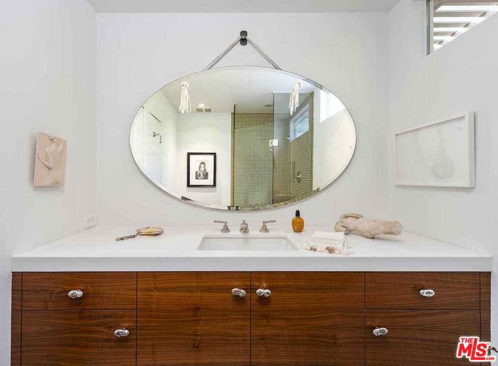 1566 Rising Glen Road Los Angeles, CA 90069 - Photo 15 of 32 a bathroom with a sink and a mirror