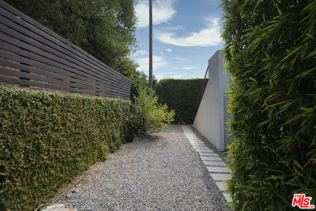 1566 Rising Glen Road Los Angeles, CA 90069 - Photo 25 of 32 a view of a yard with plants and a pathway of a house
