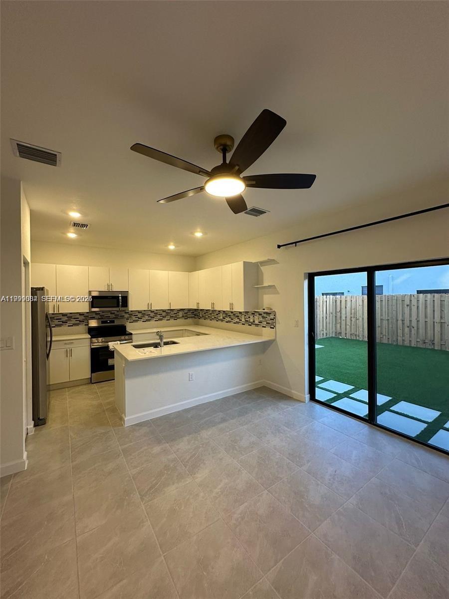 12868 Southwest 232nd Terrace Homestead, FL 33032 - Photo 11 of 48 a view of a kitchen with a sink and a stove top oven
