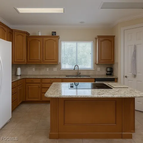 a kitchen with granite countertop a sink a stove and cabinets