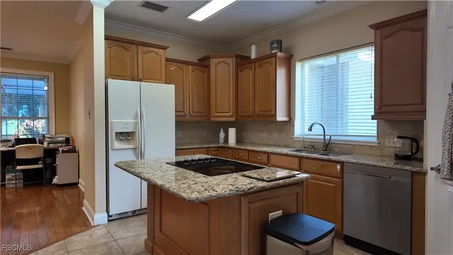 a kitchen with granite countertop a sink stove and refrigerator