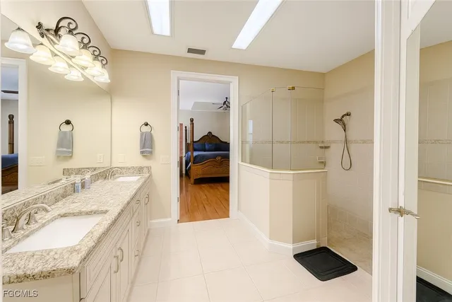 a en suite bathroom with a granite countertop sink a mirror and shower