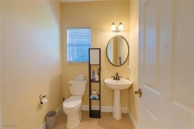 a bathroom with a sink mirror and toilet