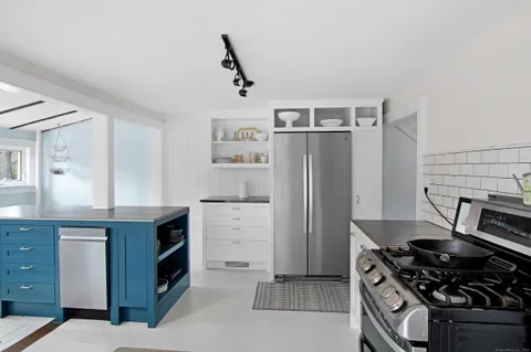 a kitchen with granite countertop a sink stove and refrigerator
