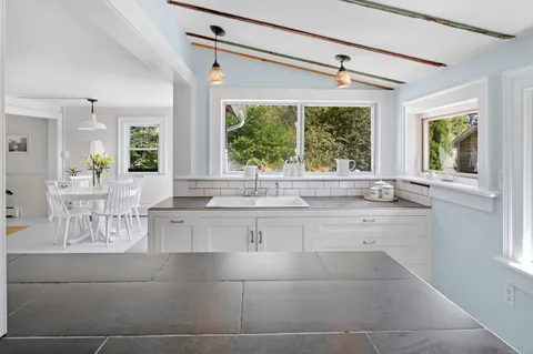 a large white kitchen with a large window